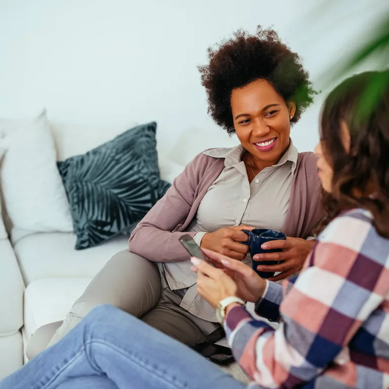 Two women talking on a couch